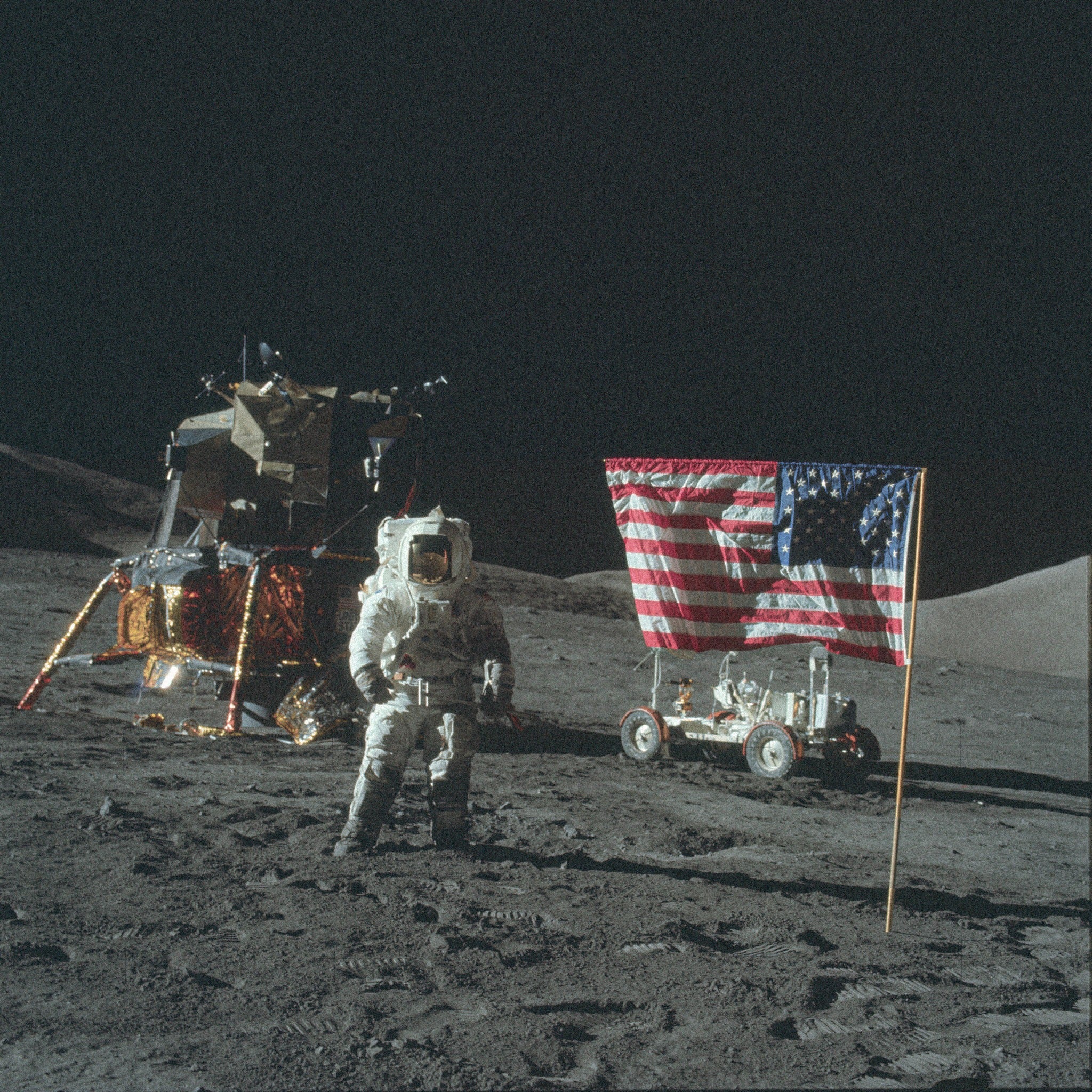 Astronaut beside a lunar module and United States flag on the Moon
