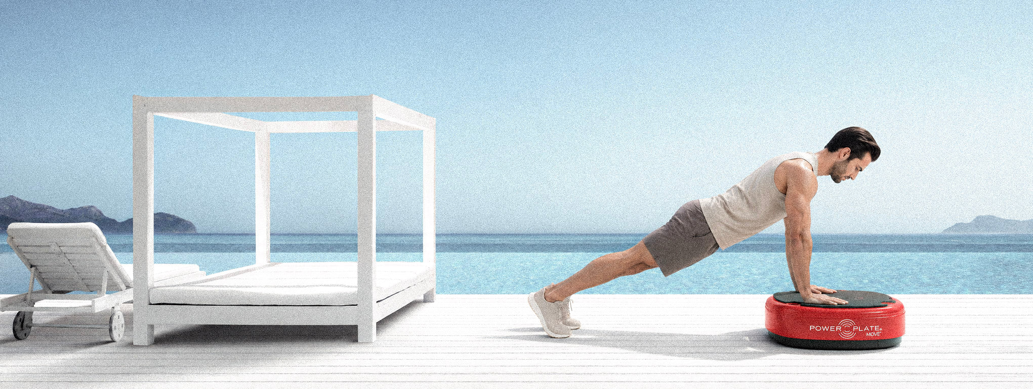 Man exercising on a red Power Plate MOVE beside a pool