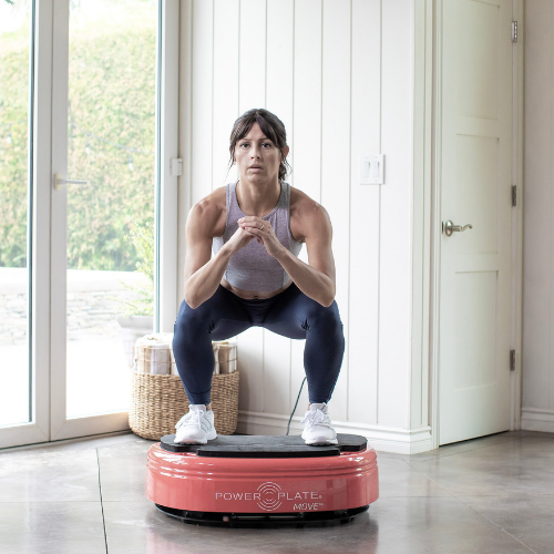 Woman exercising on a red Power Plate MOVE at home.