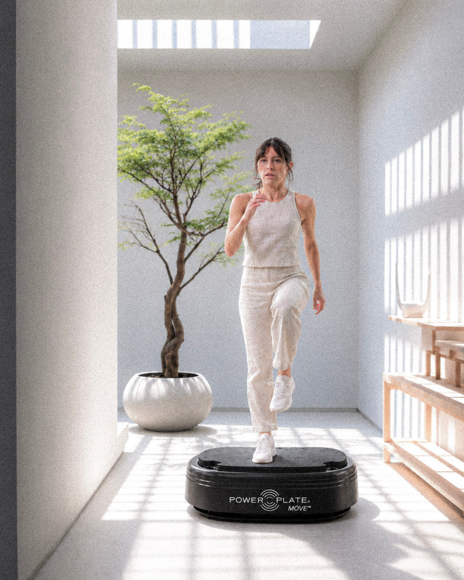 Woman exercising on a Power Plate in a bright room