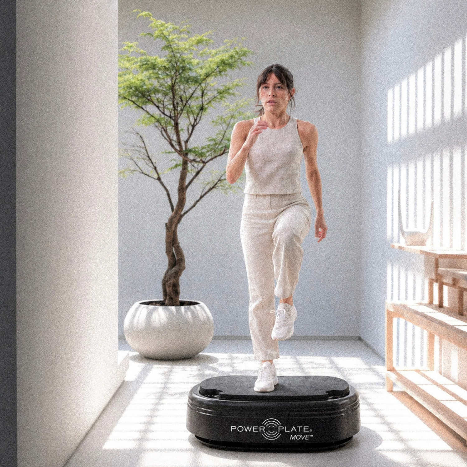 Woman exercising on a Power Plate in a bright room