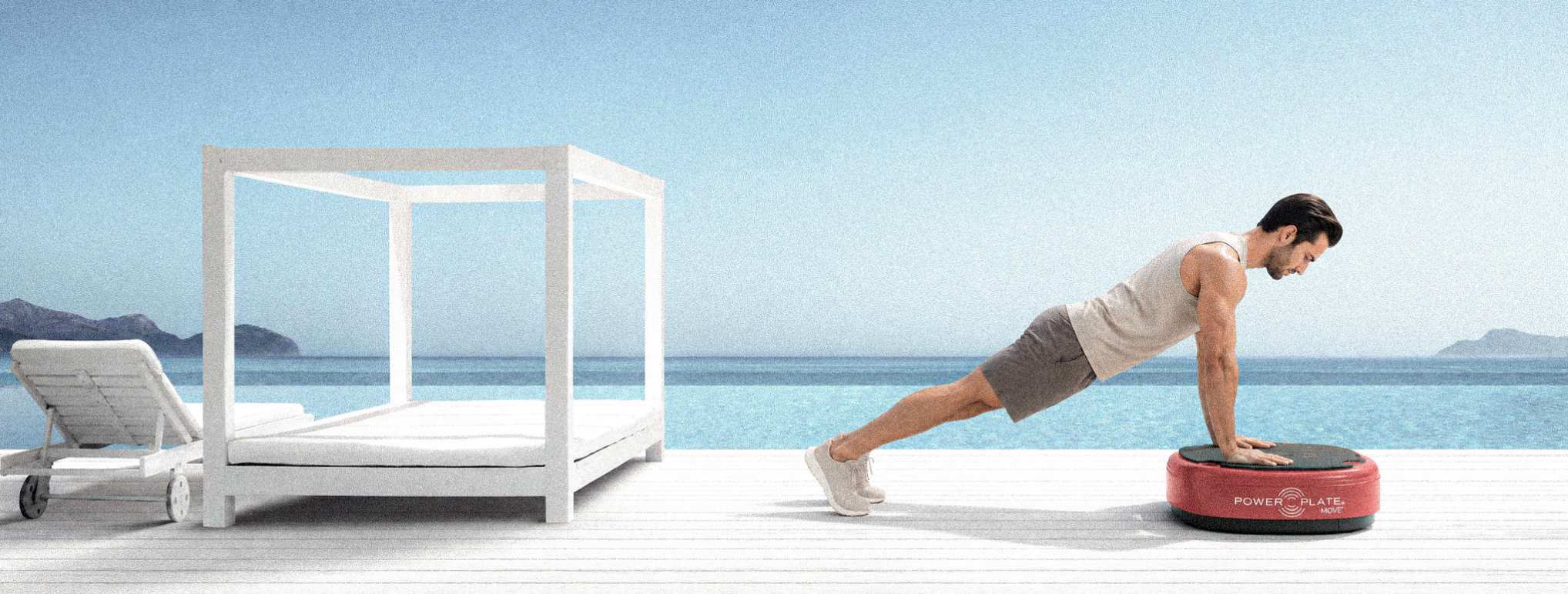 Man exercising on a red Power Plate MOVE beside the sea.